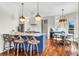 Stylish kitchen with a breakfast bar, marble countertops, modern pendant lights, and hardwood floors at 904 Watermelon Run, Charleston, SC 29412