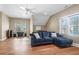 Open living room with hardwood floors, a plush blue sofa, and plenty of natural light from large windows at 904 Watermelon Run, Charleston, SC 29412