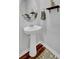 Pedestal sink and decorative shelves complement the half bathroom's design at 9981 Winged Elm St, Ladson, SC 29456