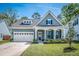 Inviting two-story home with landscaped front yard, white pillars, and black shutters at 9981 Winged Elm St, Ladson, SC 29456