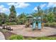 Community playground with swings and slides surrounded by lush landscaping and benches at 9981 Winged Elm St, Ladson, SC 29456
