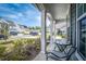 Cozy front porch view with patio seating, flowers, and neighborhood street at 9981 Winged Elm St, Ladson, SC 29456