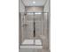 Close-up of the glass enclosed shower with a tiled surround and shower bench at 9981 Winged Elm St, Ladson, SC 29456