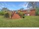 Brick home exterior showcasing a brick staircase leading to a back deck, with a lush, green lawn at 1004 Wheeler Dr, Hanahan, SC 29410