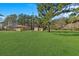 Spacious backyard with lush green grass, storage shed, and mature trees at 102 Wright Ln, Goose Creek, SC 29445