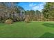 Vast backyard featuring a well-manicured lawn surrounded by mature trees and shrubs at 102 Wright Ln, Goose Creek, SC 29445