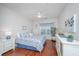Bright bedroom features hardwood floors, white walls, and a matching bedspread and window valance in blue floral pattern at 1025 Riverland Woods Pl # 801, Charleston, SC 29412