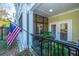 Outdoor patio with American flag, black metal railings, screened-in doors, and various potted plants at 1025 Riverland Woods Pl # 801, Charleston, SC 29412