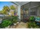 Covered outdoor patio with black metal railings, plants, American flag, a screen door, and chairs at 1025 Riverland Woods Pl # 801, Charleston, SC 29412