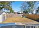 A spacious backyard features a wooden fence, a shed, and a cozy seating area with two chairs at 1079 Lockhart St, North Charleston, SC 29405