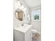 Bathroom with a stylish vanity, round mirror, and a window that provides natural light at 1079 Lockhart St, North Charleston, SC 29405