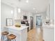 Bright kitchen features white cabinets, stainless steel appliances, a breakfast bar, and a view of the laundry room at 1079 Lockhart St, North Charleston, SC 29405
