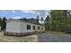 Newly constructed home with vinyl siding, brick skirting, fresh gravel driveway, and wooden porch steps at 111 Sandy Oaks Ln, Cross, SC 29436