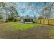 A large backyard with sparse grass and a white home with a screened-in back porch at 1114 Margaret Dr, Ladson, SC 29456