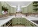 A lovely kitchen is presented with white countertops, olive green cabinetry, and stainless steel appliances at 1114 Margaret Dr, Ladson, SC 29456
