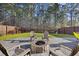 A stone fire pit is the focal point in the backyard surrounded by chairs and a wood privacy fence at 1376 Wild Goose Trl, Summerville, SC 29483