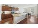Well-lit kitchen with granite countertops, dark wood cabinets, and a convenient island with a sink at 1376 Wild Goose Trl, Summerville, SC 29483