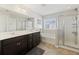 Bright main bathroom featuring double vanity, soaking tub, and glass-enclosed shower at 1376 Wild Goose Trl, Summerville, SC 29483