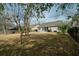 Spacious backyard featuring a large grassy area, mature trees, and an enclosed screened-in porch at 1529 Wellesley Cir, Mount Pleasant, SC 29466