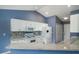 Well-lit kitchen featuring a bar, white cabinetry, and modern appliances at 1529 Wellesley Cir, Mount Pleasant, SC 29466