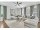 Spacious living room with a large sectional sofa, ceiling fan, and large windows with light-filtering blinds at 1878 Carolina Bay Dr, Charleston, SC 29414