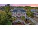Stunning two-story home with dual staircases, double porches, manicured lawn, palm trees, and spectacular views at 2040 Ashburton Way, Mount Pleasant, SC 29466