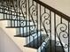 Close up of staircase showing decorative metal banister and stained wood handrail with dark-stained treads at 2040 Ashburton Way, Mount Pleasant, SC 29466