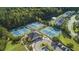 Aerial view of community tennis courts surrounded by lush greenery and a tranquil pond in a Gathering friendly neighborhood at 2040 Ashburton Way, Mount Pleasant, SC 29466