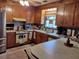 Kitchen showcasing wood cabinets, tiled floors, and appliances in a functional layout at 205 Longstreet St, Summerville, SC 29486