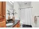 Modern bathroom featuring a bathtub, shower with white curtain, dark granite countertop, and decorative plant at 23 Lowndes Pointe Dr, Charleston, SC 29403