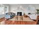 Well-lit open living area with hardwood floors, a fireplace, large windows and plush modern furnishings at 23 Lowndes Pointe Dr, Charleston, SC 29403