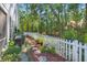 Beautifully landscaped backyard with stone pathway, lush greenery, mulch and a pristine white picket fence at 2690 Park W Blvd, Mount Pleasant, SC 29466