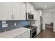 Close-up of the kitchen featuring white cabinetry, stainless steel appliances, and blue subway tile backsplash at 2690 Park W Blvd, Mount Pleasant, SC 29466