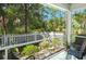 A cozy screened-in porch overlooks a serene backyard with lush greenery and a charming white picket fence at 2690 Park W Blvd, Mount Pleasant, SC 29466