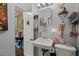 Cozy bathroom features a white sink, toilet, mirror, and a shelf with decorative items at 29 Wendy Lane, Charleston, SC 29407
