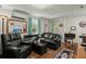 Comfortable living room featuring black leather furniture, wood-look flooring, and bright, natural light at 29 Wendy Lane, Charleston, SC 29407