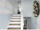 Bright entryway featuring wood and white stairs, with views of the kitchen and multiple doorways at 2901 Newport Pl, North Charleston, SC 29420