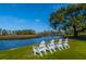 Waterfront property featuring green lawn and white Adirondack chairs overlooking the serene river at 2975 Yachtsman Dr, Mount Pleasant, SC 29466