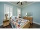 Cozy bedroom with a colorful quilt, wood floors, plantation shutters, and a dresser with a mirror at 2975 Yachtsman Dr, Mount Pleasant, SC 29466