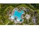 Aerial view of a resort-style pool with a slide, splashpad, and plenty of lounge chairs surrounded by lush greenery at 2975 Yachtsman Dr, Mount Pleasant, SC 29466