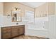 Spacious bathroom with a large vanity, soaking tub, wood-look floor and warm neutral color palette at 301 Forsythia Ave, Summerville, SC 29483