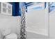 Bright bathroom with a white tiled shower-tub, blue walls, and a window providing natural light at 301 Forsythia Ave, Summerville, SC 29483
