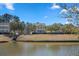 Scenic view of a waterfront community, showcasing a tranquil pond, lush greenery, and well-maintained homes at 301 Forsythia Ave, Summerville, SC 29483