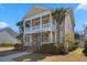 Charming two-story home featuring a double porch, landscaped yard, and palm trees at 301 Forsythia Ave, Summerville, SC 29483