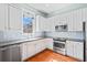 Bright kitchen boasts stainless appliances, stylish backsplash, and white cabinetry at 301 Forsythia Ave, Summerville, SC 29483