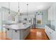 Modern kitchen featuring stainless appliances, white cabinetry, large island, and stylish pendant lighting at 301 Forsythia Ave, Summerville, SC 29483