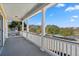 Spacious porch with classic white columns, offering a scenic view of the neighborhood and a tranquil pond at 301 Forsythia Ave, Summerville, SC 29483