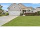 Charming single-Gathering home with a well-manicured lawn, mature tree, and covered front porch at 303 Sand Dune Trl, Summerville, SC 29486