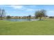 Scenic view of the pond and surrounding community homes, complemented by green lawn at 303 Sand Dune Trl, Summerville, SC 29486