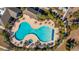 Aerial view of a resort-style swimming pool surrounded by lush landscaping and patio furniture at 303 Sand Dune Trl, Summerville, SC 29486